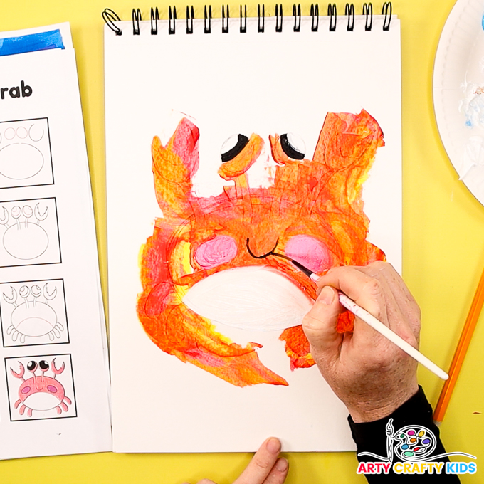 The image shows a hand painting a smile in black.