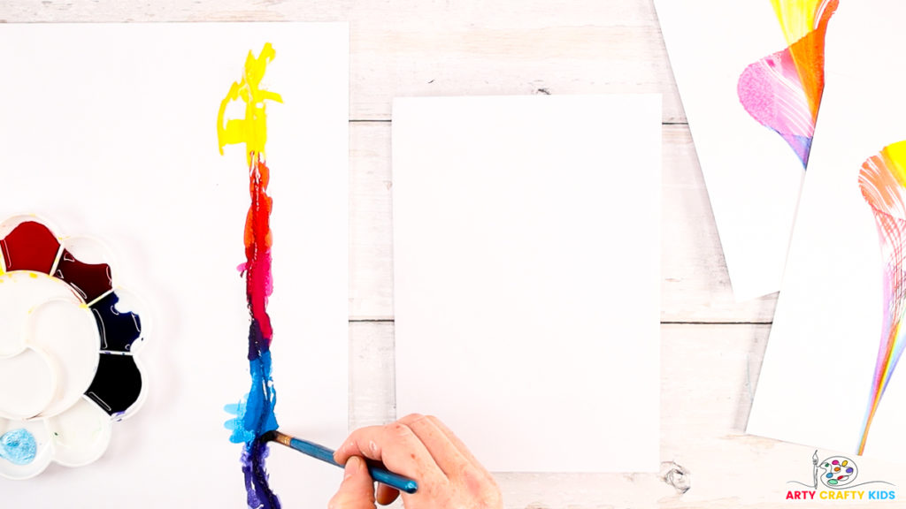 A hand painting the string with watercolor paint.
