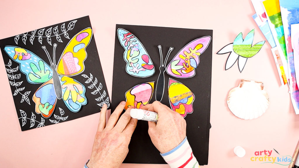 Image of a hand glueing the Matisse shapes into place.