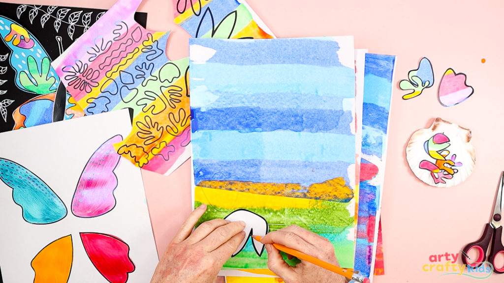 Image of a hand tracing a Matisse shape onto painted paper.