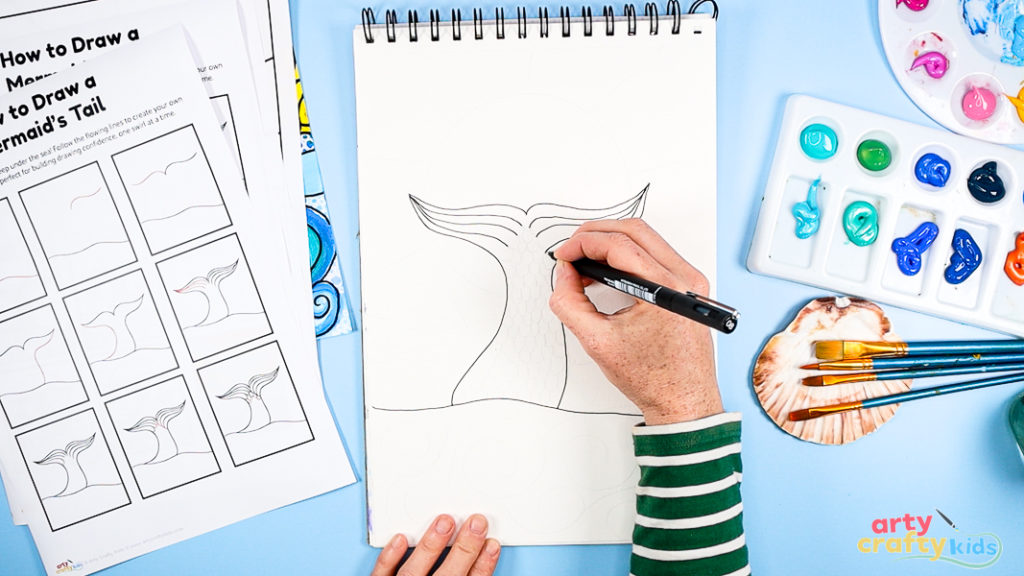 Image of Step 3: Drawing repeated scallop patterns inside the tail to create scale texture, supporting pattern recognition and hand control.