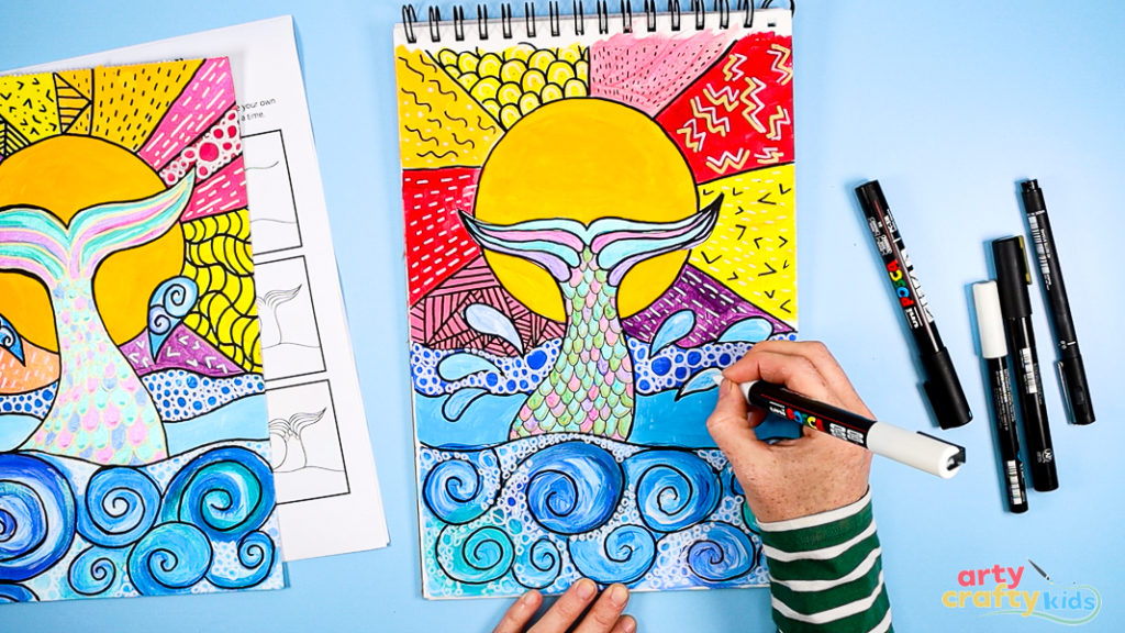 Image of Step 10: Adding patterns and doodles using white, black, and metallic pens—circles in the waves and line patterns in the sun for added texture and detail.