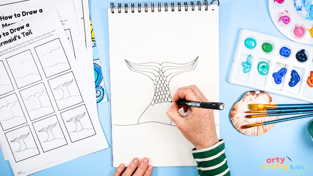 Image of Step 3: Drawing repeated scallop patterns inside the tail to create scale texture, supporting pattern recognition and hand control.