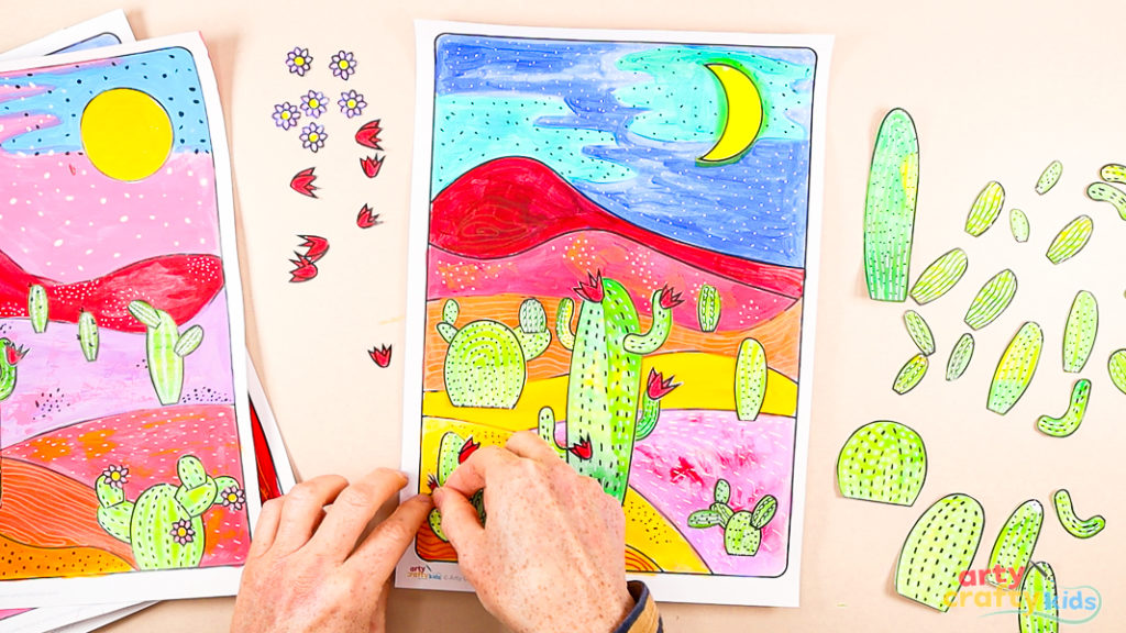 Image of a hand assembling the cactus elements onto the desert landscape.