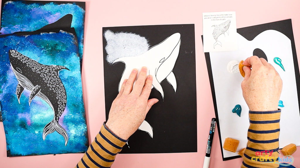Hands dabbing white paint around the Whale Shark template.
