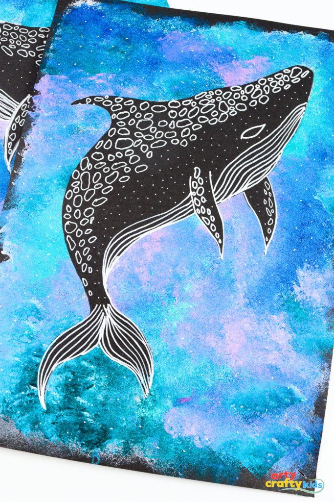 Whale shark silhouette painting featuring a bold black whale shark shape over a textured ocean background in shades of blue, purple, and pink. The silhouette is decorated with white line patterns and dots to mimic the whale shark’s markings. A simple ocean-themed art project for kids.