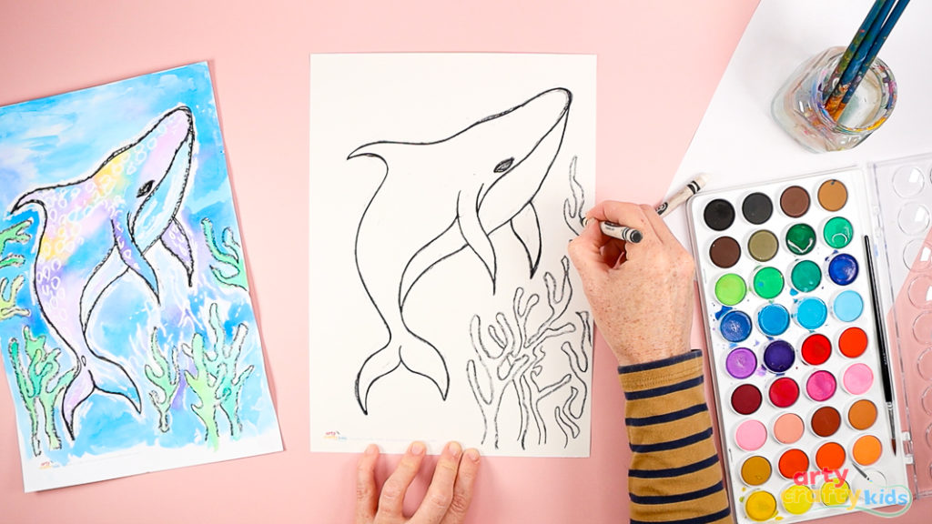 Image of a hand framing the whale shark with drawings of seaweed - in black crayon.