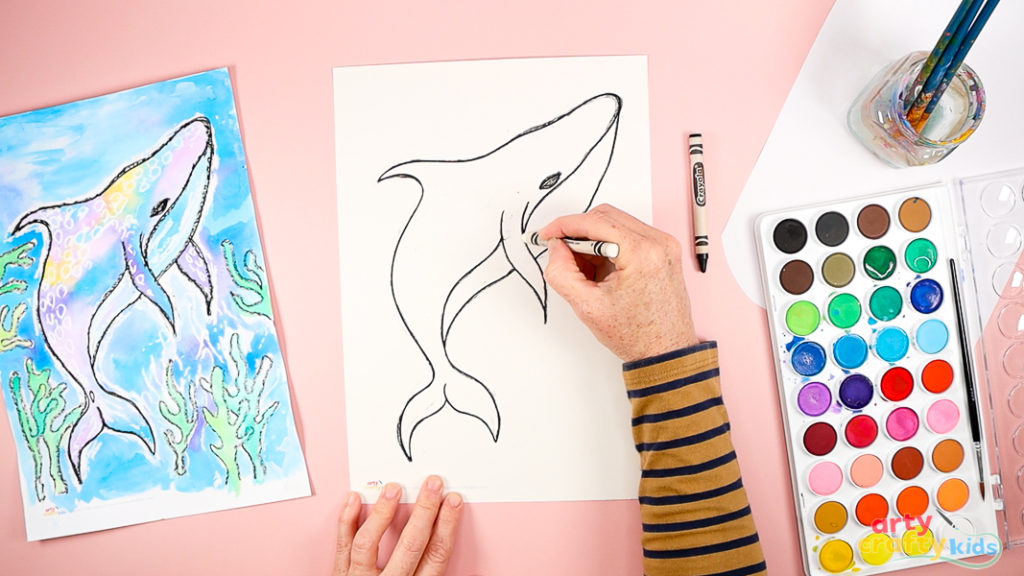 Image of a hand drawing whale shark detailing in white crayon.