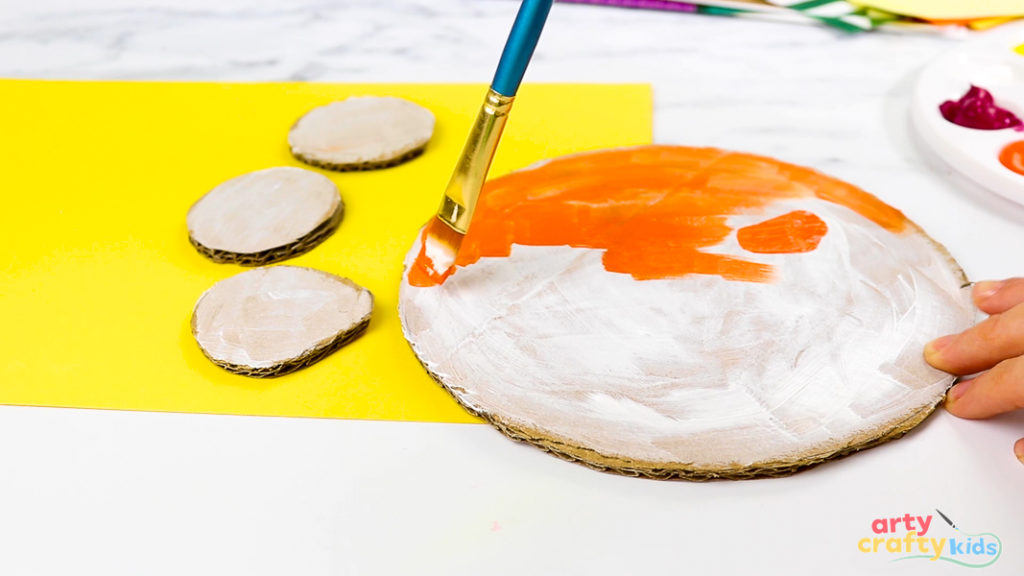 Hand painting the lions head orange.