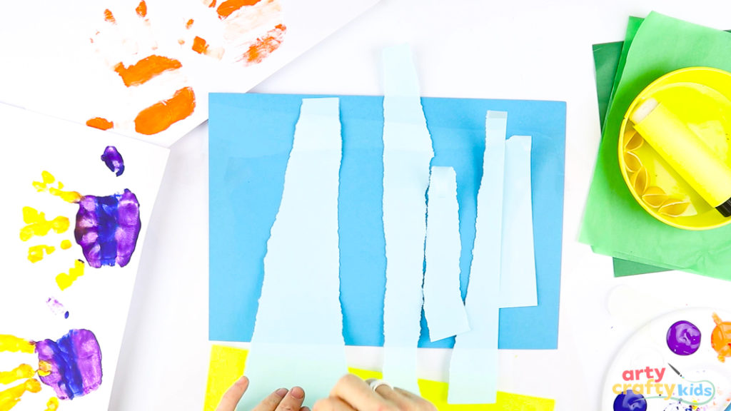 Image of a blue paper sheet with torn light blue strips placed on top.
