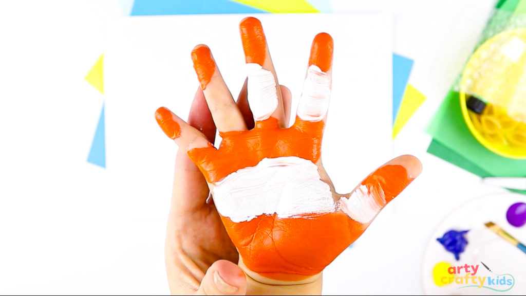 Image of a hand painted orange and yellow to mimic a clownfish.