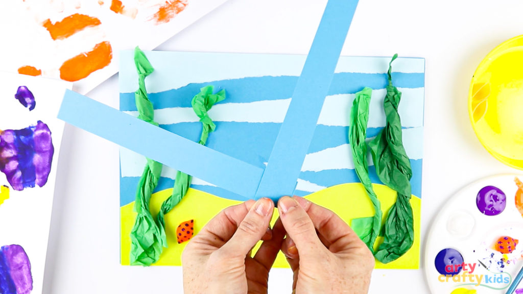 Image of a hand folding paper strips to create an accordion fold.