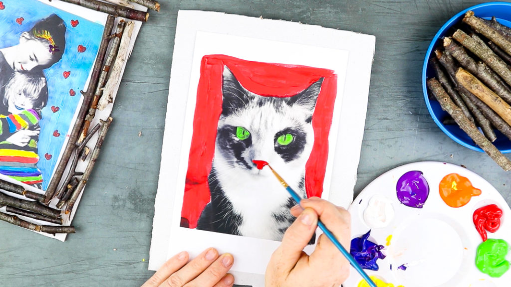 Image showing hands painting the cat's eyes green and nose red.