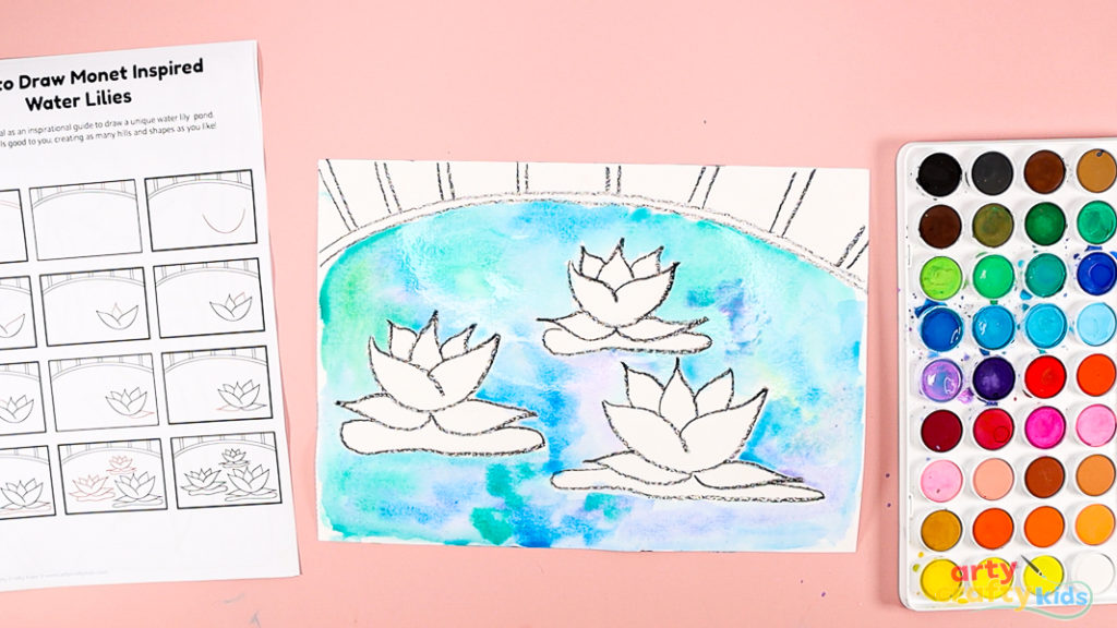 Image of a hand painting the space around the water lilies, a mix of blue and green.