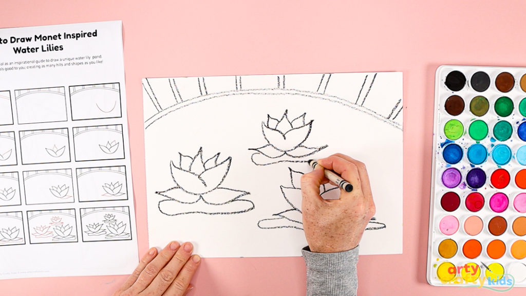 Features a hand using a printed how-to-draw guide to draw the water lily.