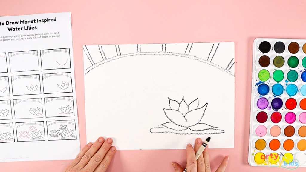 Features a hand using a printed how-to-draw guide to draw the water lily.