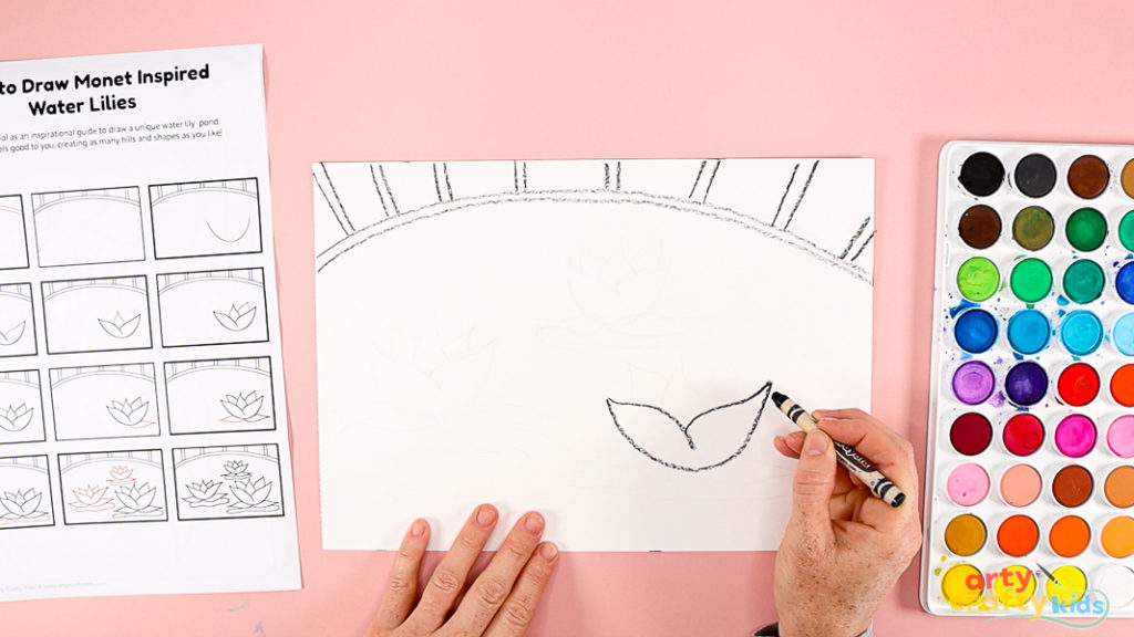 Features a hand using a printed how-to-draw guide to draw the water lily.