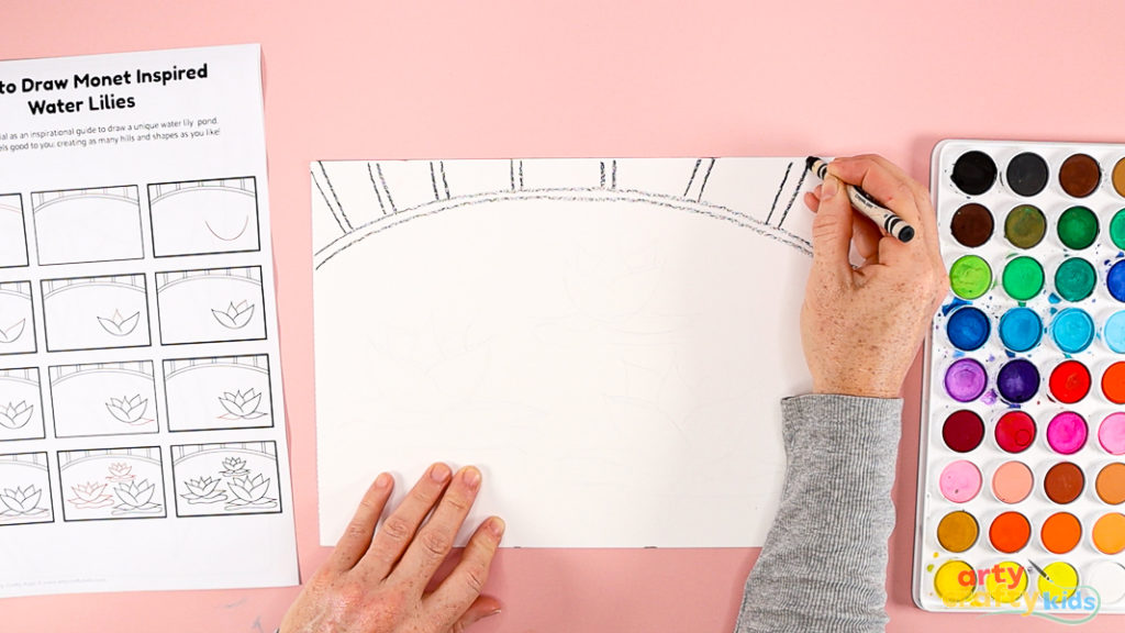 Features a hand using a printed how to draw guide to draw the bridge.