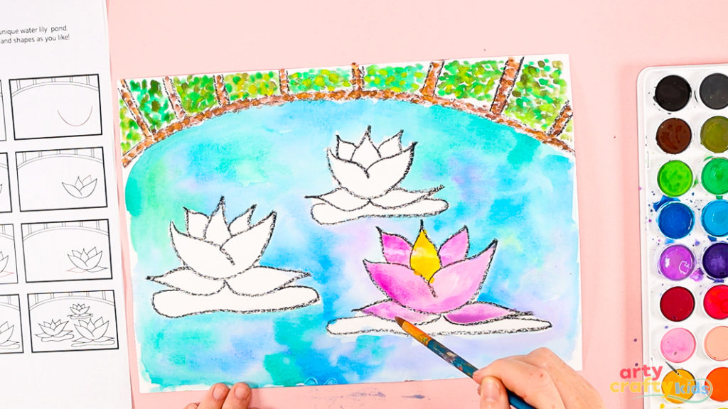 Image of a hand painting the water lily pink, purple with hints of white.