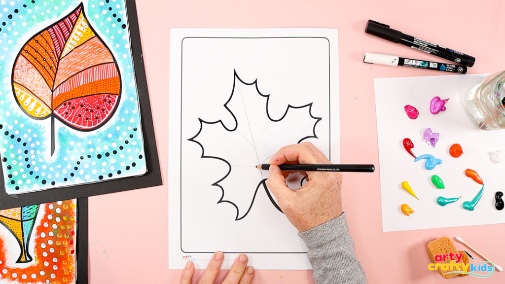 Image featuring a hand using a pencil to faintly draw lines that divide the leaf template. 