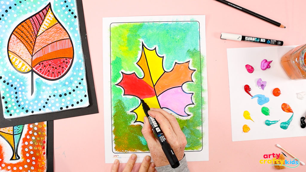 Image of a hand using a black marker pen to define the segments of the leaf. 