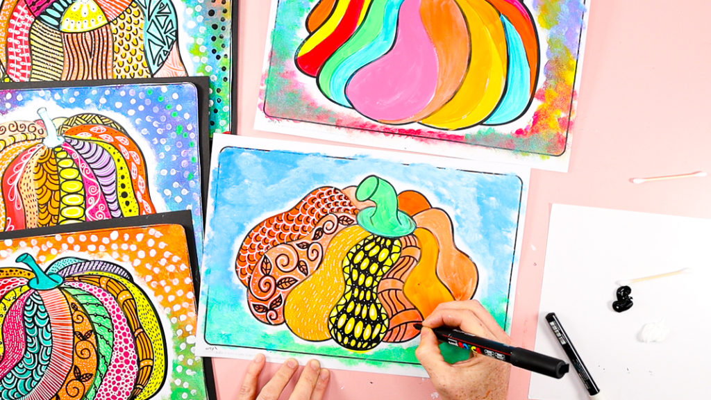 Image of a hand drawing patterns into the individual pumpkin segments. 