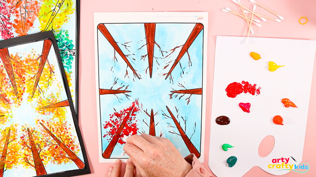 Painting the first tree red, using the q-tips to create a dotty effect.