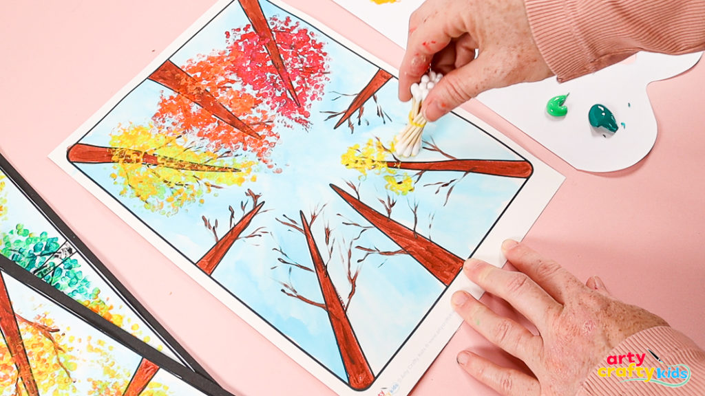 Trees painted orange, yellow and red with q-tips - all with a layered dotty effect.