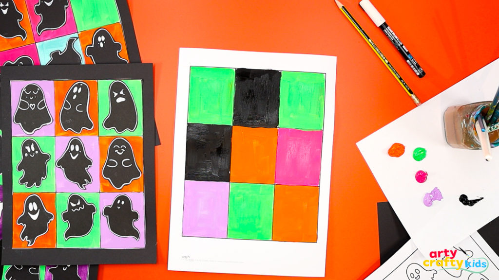 Painting a Pop Art-style grid in Halloween colors of orange, green, purple, and black for a ghost art project inspired by Andy Warhol.