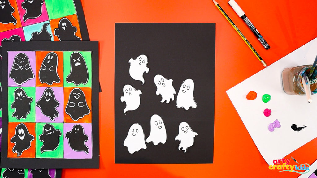 Cutting out playful ghost illustrations from a template for a Pop Art Ghost Halloween craft inspired by Andy Warhol.