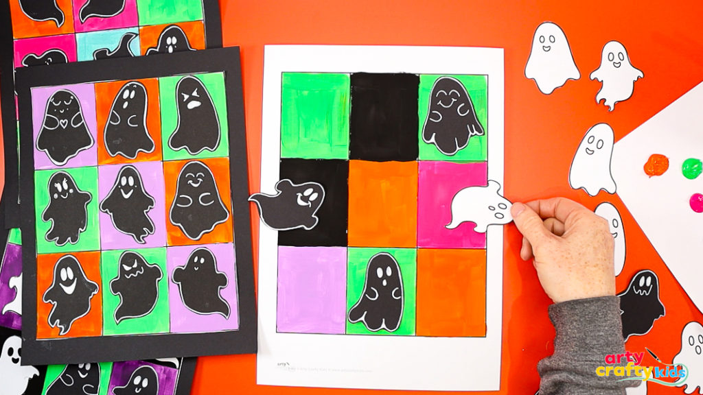 Arranging cut-out ghosts onto a colorful Pop Art grid for a fun Halloween art project inspired by Andy Warhol.