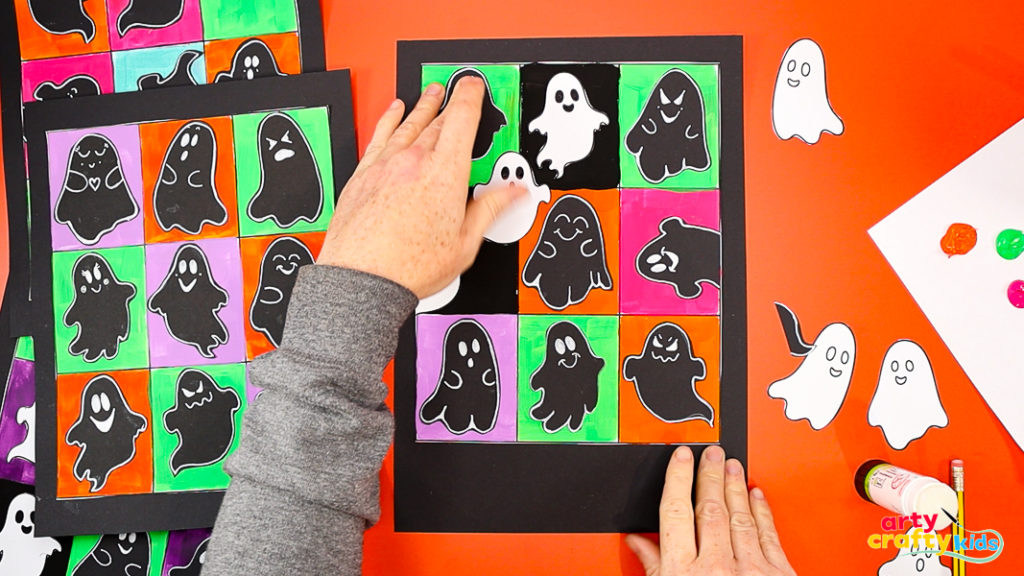 Arranging cut-out ghosts onto a colorful Pop Art grid for a fun Halloween art project inspired by Andy Warhol.